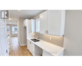 A kitchen with white cabinets and a countertop.