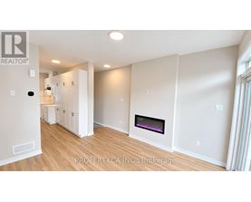 A well-lit, spacious living room with a fireplace and a realtor logo.