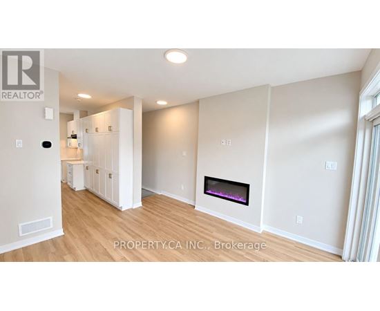 A well-lit, spacious living room with a fireplace and a realtor logo.
