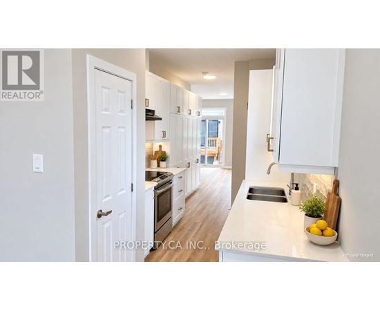 A white kitchen with a sink and a window.