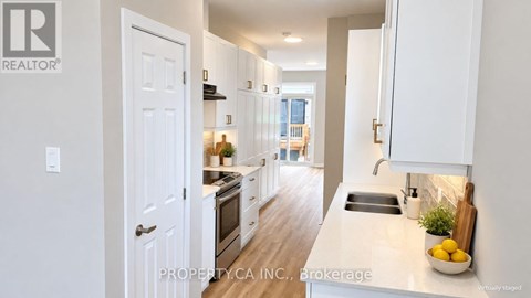 A white kitchen with a sink and a window.