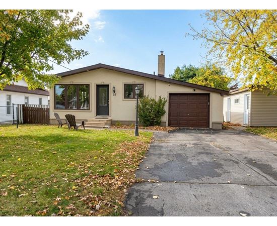 A house with a brown garage door and a black metal fence.