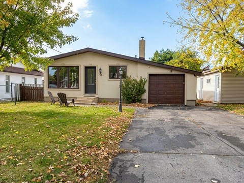 A house with a brown garage door and a black metal fence.