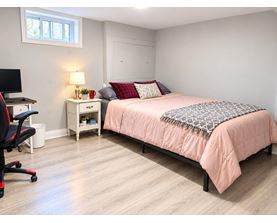 A bedroom with a bed, desk, and chair.
