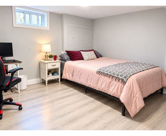 A bedroom with a bed, desk, and chair.