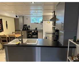 A kitchen with a sink and a refrigerator.