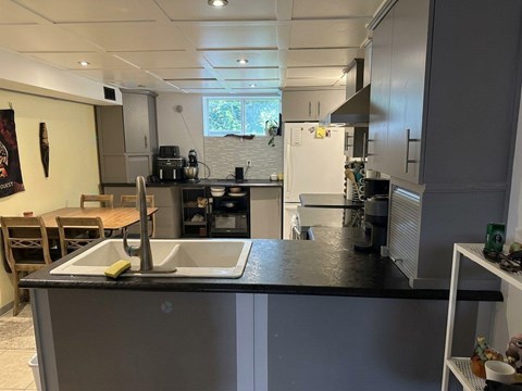 A kitchen with a sink and a refrigerator.