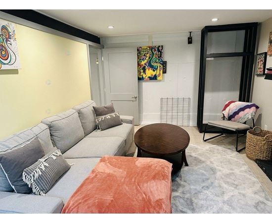 A living room with a grey couch and a brown coffee table.