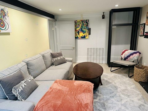 A living room with a grey couch and a brown coffee table.