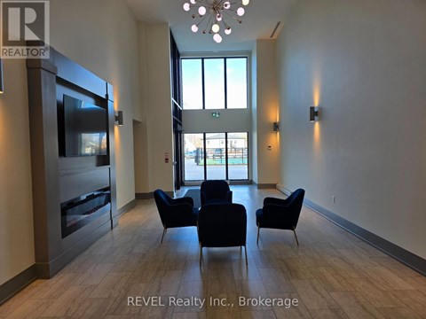 A living room with a television, chairs, and a large window.