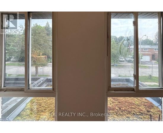 A window with a view of a street and houses.