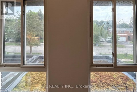 A window with a view of a street and houses.