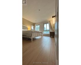 A bedroom with a large bed and a window with curtains.