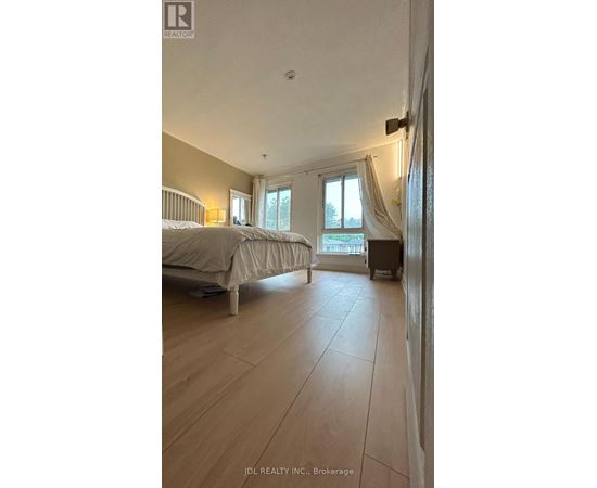 A bedroom with a large bed and a window with curtains.