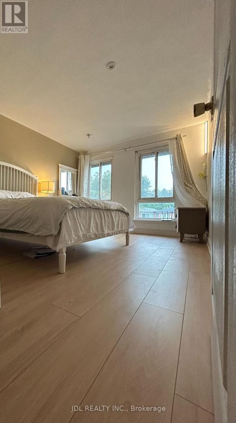A bedroom with a large bed and a window with curtains.