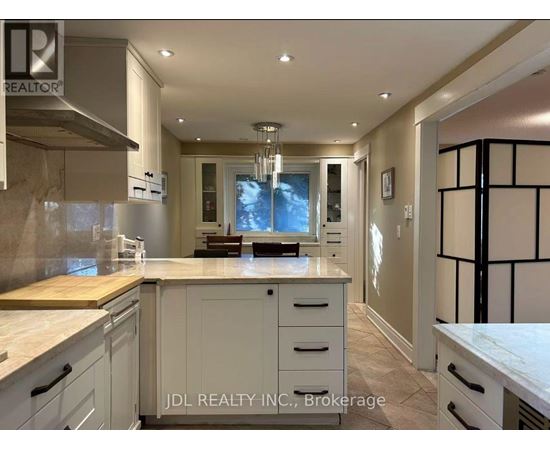 A modern kitchen with white cabinets and a wooden island.