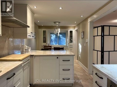 A modern kitchen with white cabinets and a wooden island.