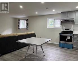 A kitchen area with a table and a stove.