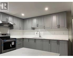 A kitchen with grey cabinets and a white countertop.
