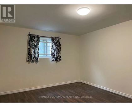 A room with a window and curtains, with the logo "REALTOR" on the wall.