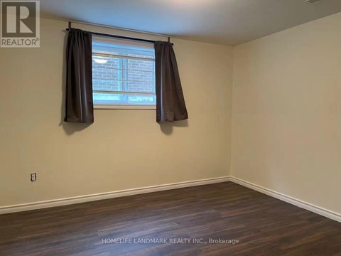 A room with a window and a wooden floor.