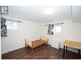A bedroom with a bed, a table, and a cabinet.