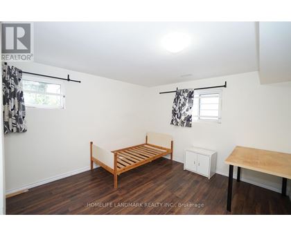 A bedroom with a bed, a table, and a cabinet.