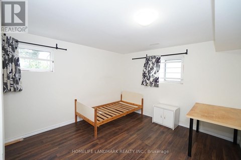 A bedroom with a bed, a table, and a cabinet.