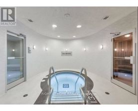 A modern indoor swimming pool with a glass bottom.
