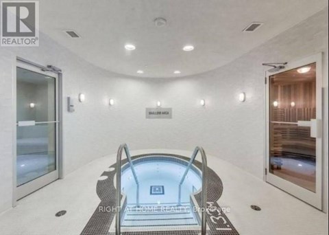 A modern indoor swimming pool with a glass bottom.