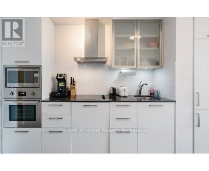 A kitchen with white cabinets and a black countertop.