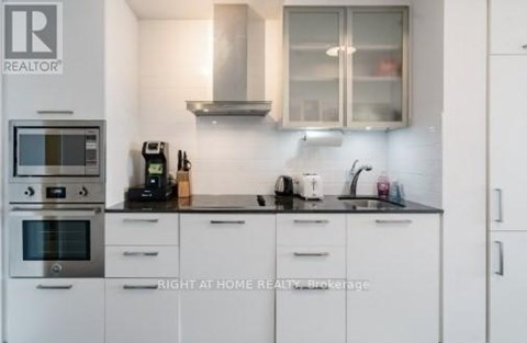 A kitchen with white cabinets and a black countertop.
