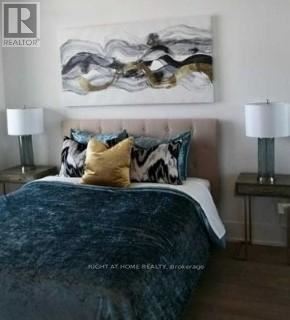 A bedroom with a large bed and a painting on the wall.