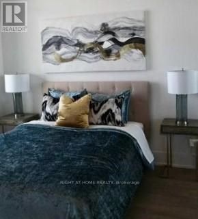 A bedroom with a large bed and a painting on the wall.