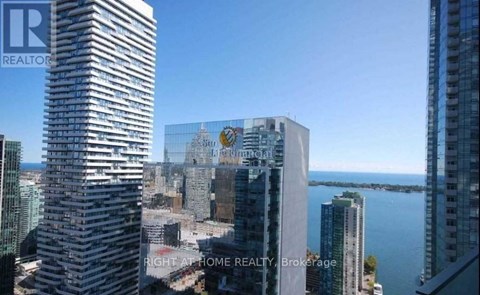 A cityscape with buildings and a body of water in the distance.
