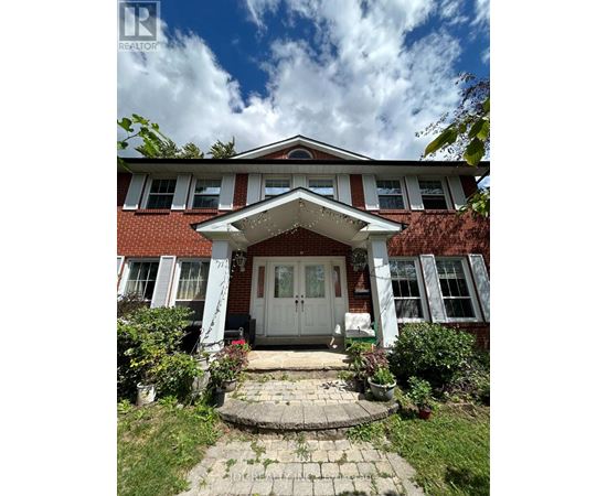 A red brick house with a white door and windows.