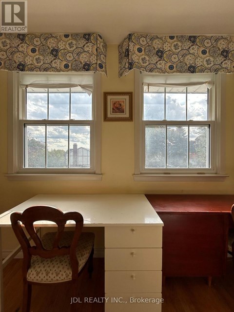 A room with a desk and chair in front of a window.