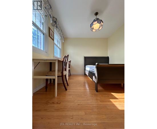 A bedroom with a bed, chair, and window.