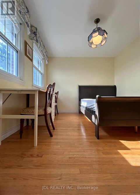 A bedroom with a bed, chair, and window.