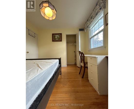 A bedroom with a bed, desk, and chair.