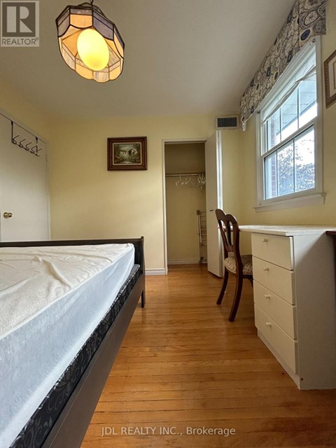 A bedroom with a bed, desk, and chair.