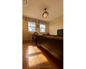 A room with wooden floors and a window with curtains.