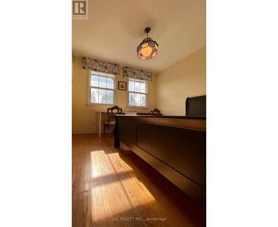 A room with wooden floors and a window with curtains.