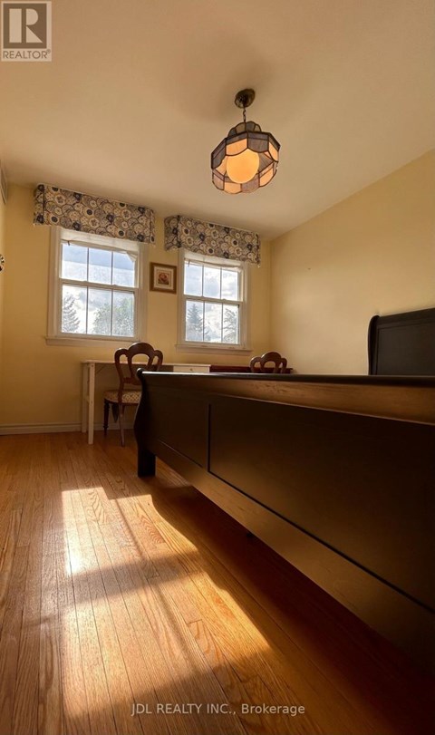 A room with wooden floors and a window with curtains.