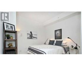 A bedroom with a bed, a nightstand, and a shelf with a plant and a star decoration.