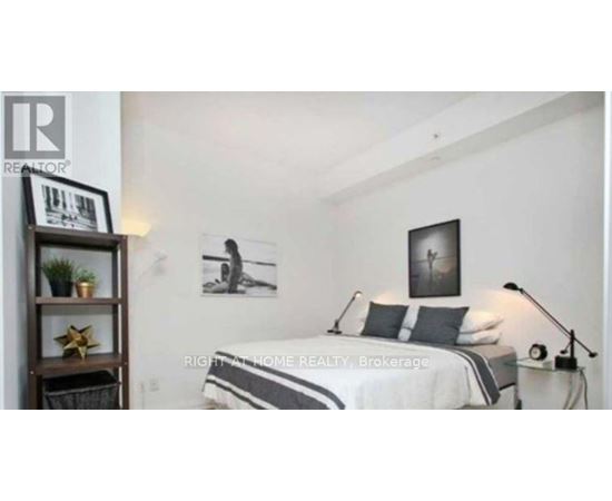 A bedroom with a bed, a nightstand, and a shelf with a plant and a star decoration.