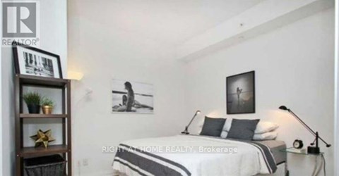 A bedroom with a bed, a nightstand, and a shelf with a plant and a star decoration.