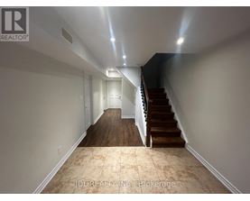 A hallway with a staircase and a light on the ceiling.