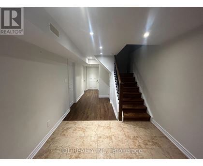 A hallway with a staircase and a light on the ceiling.
