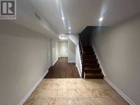 A hallway with a staircase and a light on the ceiling.